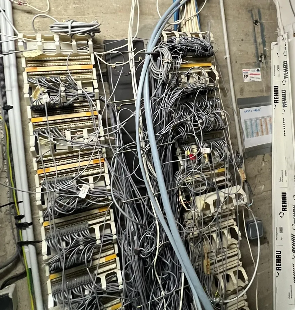 Répartiteur téléphonique avant intervention : câbles en vrac devant les réglettes